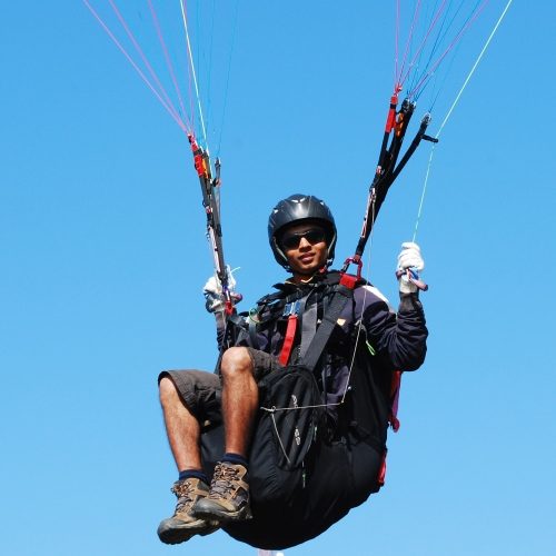 Pilot sitting in the harness with hands on controls Pilot sitting in the harness with hands on controls
